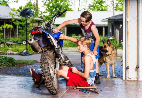 Young boys in a garage with a motocross